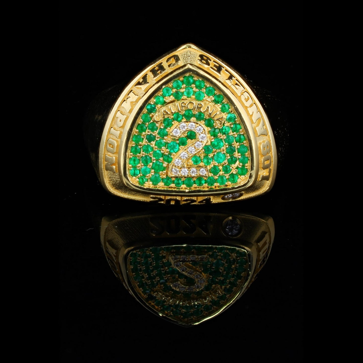 Champion ring in 18ct yellow gold, inspired by Super Bowl rings, with pavé emeralds and round diamonds.