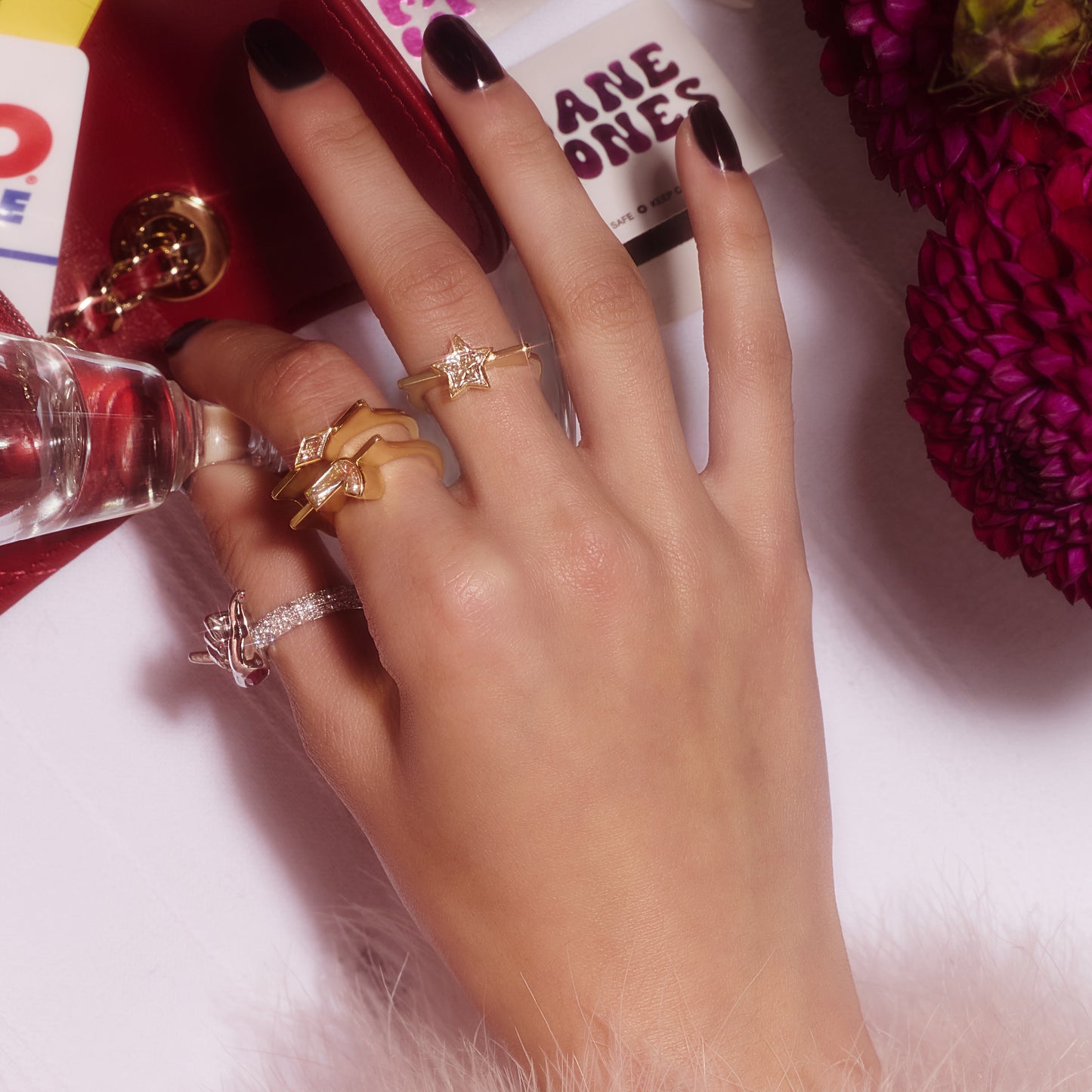 Lozenge-cut lab-grown diamond Highline ring in yellow gold, stacked with other rings on a hand.