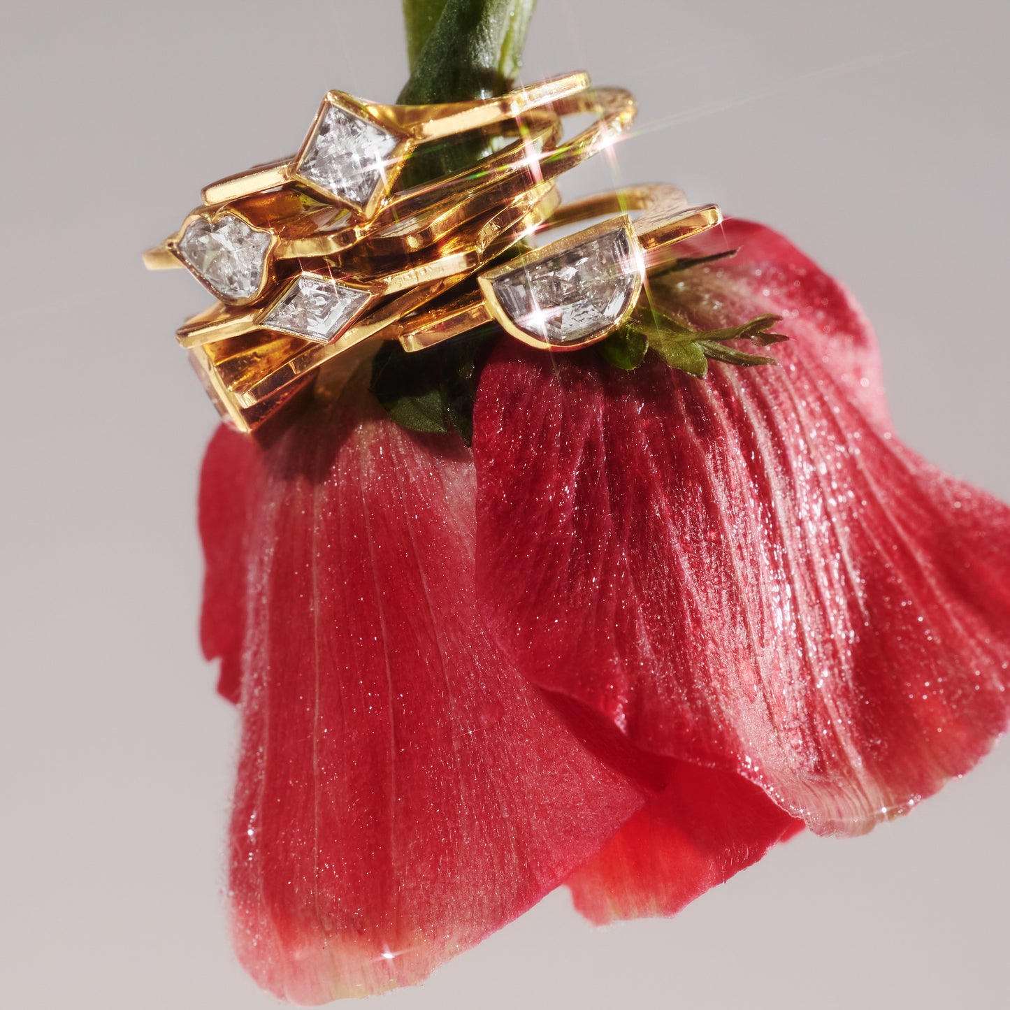 Stack of rings on a rose stem featuring the Highline half moon–cut lab-grown diamond ring in 18ct yellow gold.