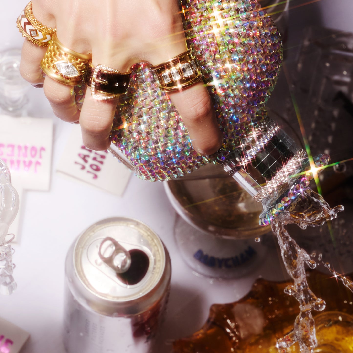 Belt-inspired 18ct yellow gold ring with black enamel and pavé diamond buckle, worn on a hand with other rings.