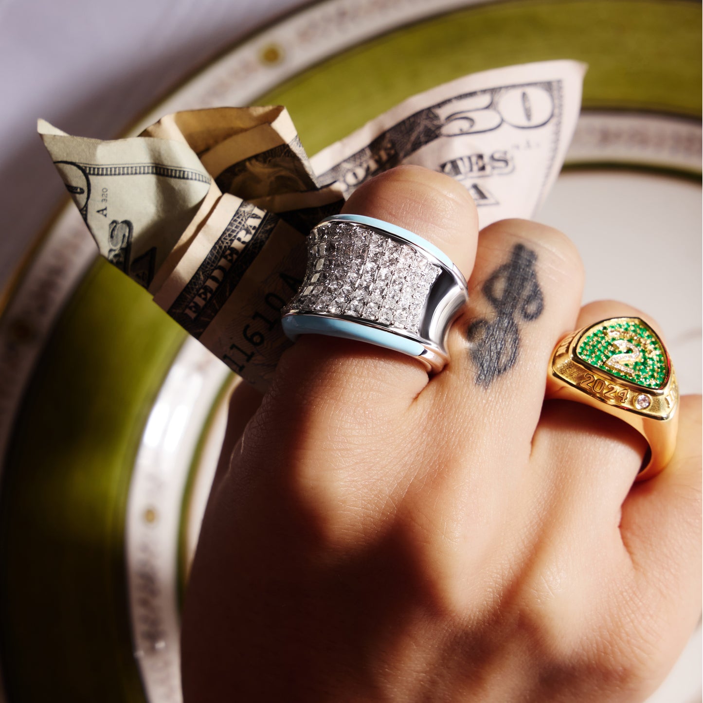 CHAMPION signet ring in yellow gold with pavé emeralds and diamonds, worn on a hand.